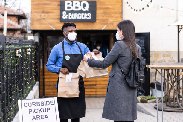 istock Waitstaff delivering take-out food from the curbside pickup area 1309966314
