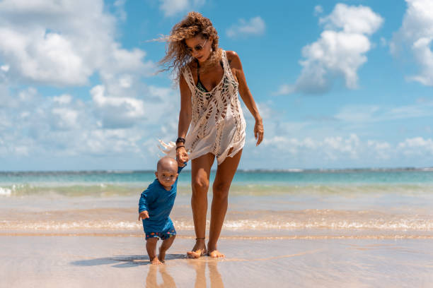 istock Mother helping her son in the first steps on the tropical beach 1309967867