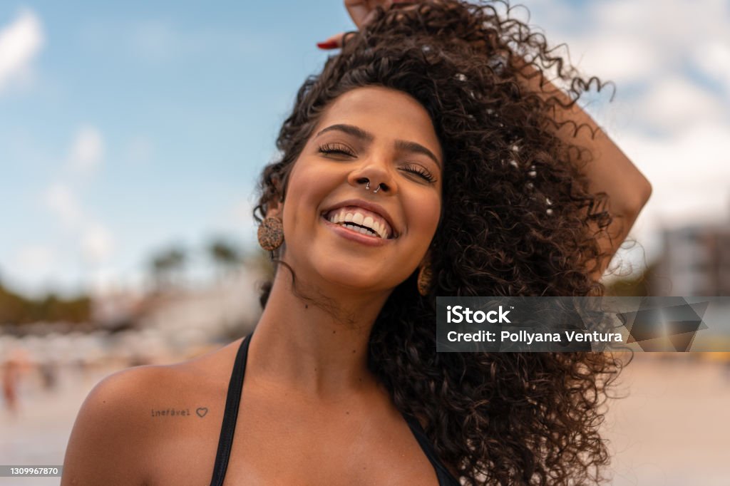 Portrait of woman with nose ring Portrait, Young, Afro, Smiling, Beach Curly Hair Stock Photo