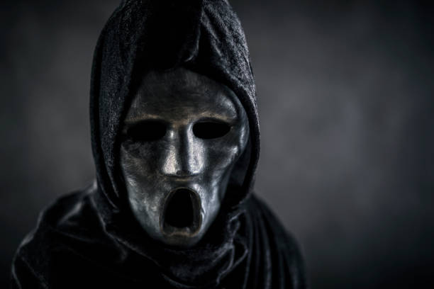 istock Scary figure with hooded cape in the dark 1309968558