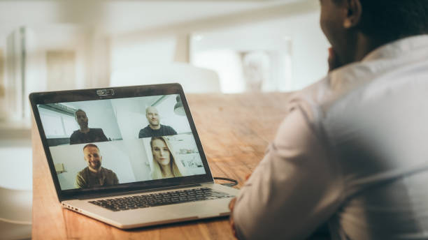 istock Home office video call with team. African man using laptop 1309971212