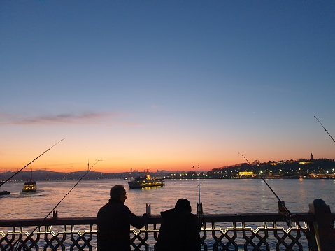 Istanbul, Turkey - July 19: Amateur fisherman is fishing on Cengelkoy Coastline at sunset on July 19, 2018 in Istanbul, Turkey.