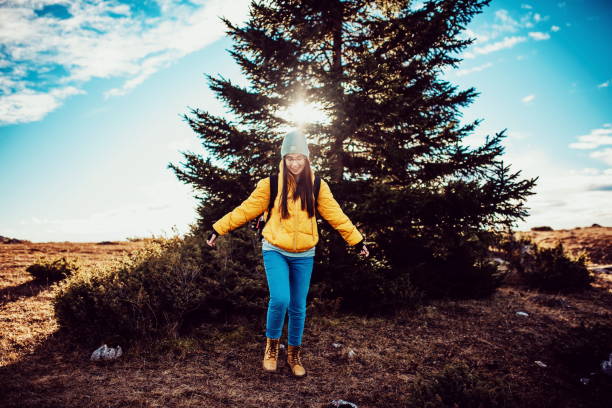istock a woman with outstretched arms running through nature 1309972749