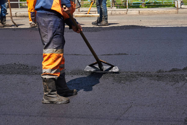 istock Road surface repair. Workers are laying asphalt on the road 1309975265