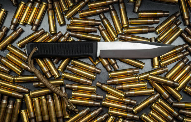 un moderno esercito o coltello da caccia sullo sfondo di casi di pistola. - blade steel shiny contemporary foto e immagini stock
