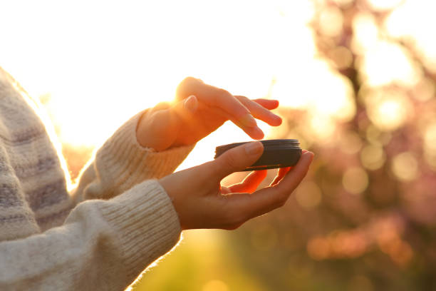 istock Woman hands applying moisturizer cream at sunset 1309978317