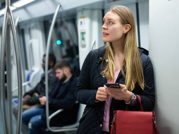 istock Young woman with phone in subway car 1309978342