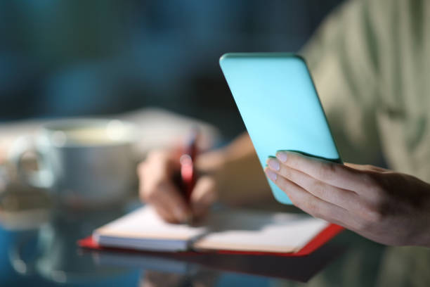 istock Woman hands checking phone agenda and taking notes 1309978355