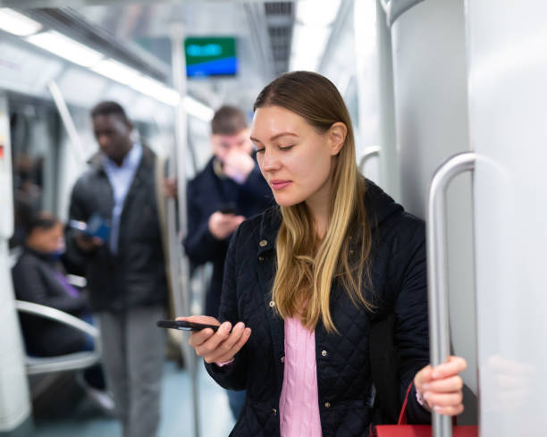 istock Girl using mobile phone in metro car 1309978362