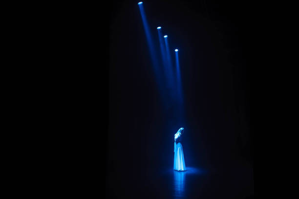 istock Actress, singer on stage in the rays of blue light. 1309978419