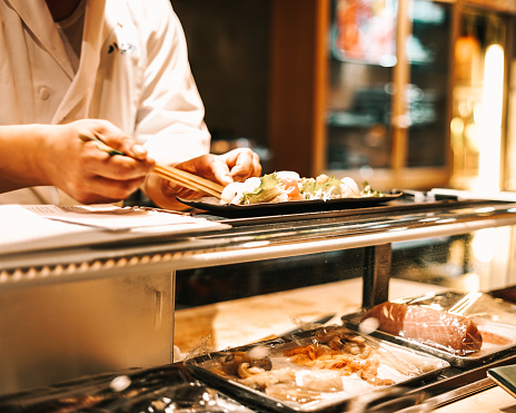 Hands of chef preparing fresh sushi and sashimi. Tokyo, Japan