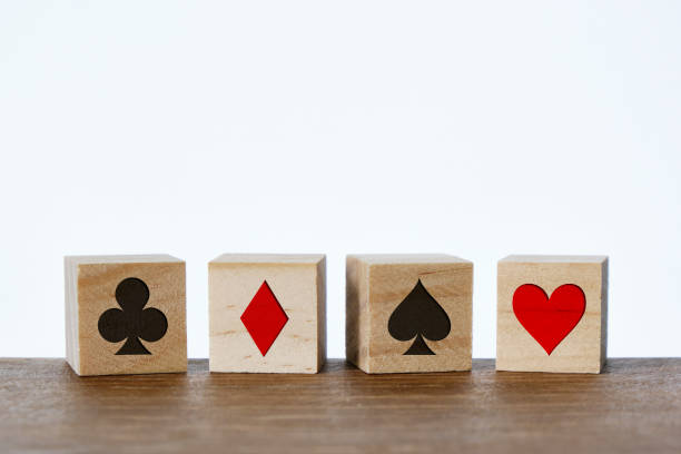 Card suit symbols on wooden blocks, white background. Horizontal composition with copy space.