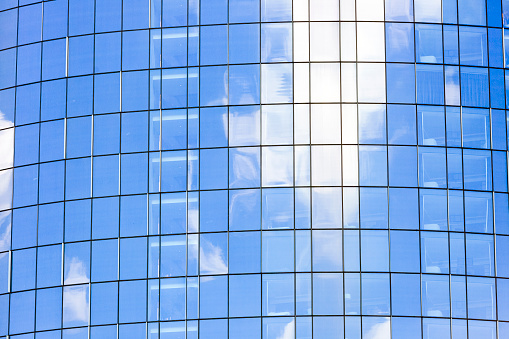 Glass wall of modern skyscraper with reflection, abstract background with copy space, full frame horizontal composition