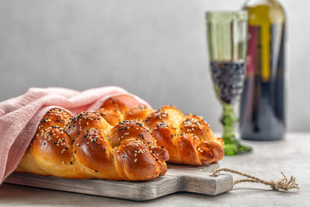 dwa bochenki domowego chleba challah z różową okładką, kieliszek wina w tle. jasnoszare tło. selektywne skupienie. kopiuj miejsce. - hanukkah loaf of bread food bread zdjęcia i obrazy z banku zdjęć