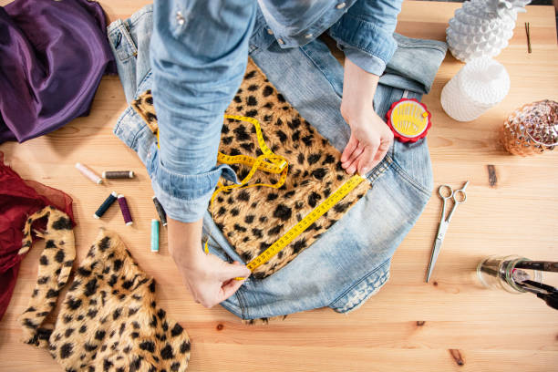 stilista che lavora in laboratorio di moda realizzando giacca fatta a mano - denim jacket foto e immagini stock