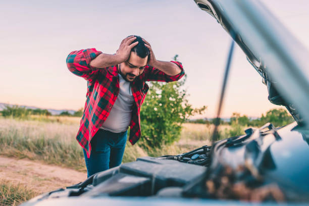 istock Man on the road with broken car 1309987809