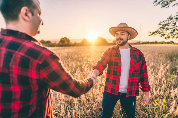 istock Farmers shaking hands in wheat field 1309987831