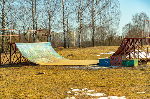 An abandoned painted rusty skate and roller ramp on the outskirts of town. High quality photo