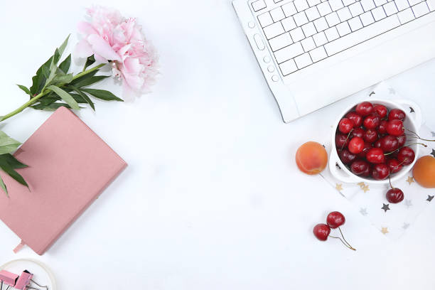 modern woman's desktop, home office, cup with cherries and peonies on a light table. healthy breakfast with ingredients, healthy lifestyle concept, flat lay, - flower cherry cup tea imagens e fotografias de stock