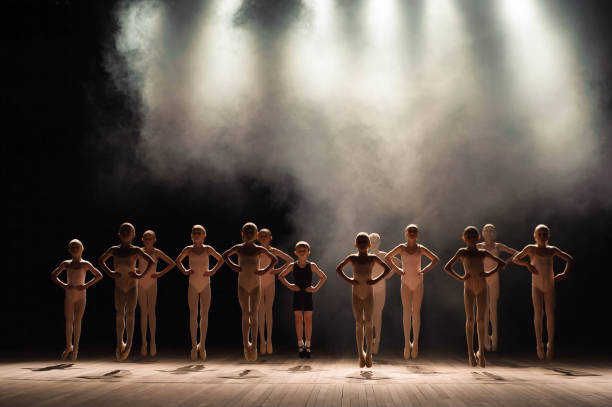 istock Young ballerinas rehearsing in the ballet class. They perform different choreographic exercises and stand in different positions 1309991011