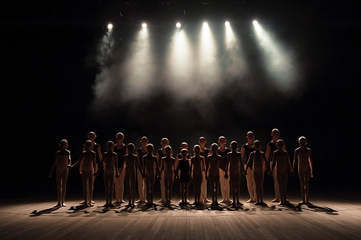 a large group of children have a reverence at the end of the performance