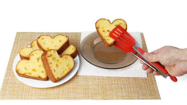 istock Hand holds clip so that heart shaped cupcake puts it on separate plate next to others 1309991236