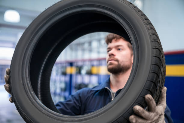 car mechanic checking tire - repairing auto repair shop service technician imagens e fotografias de stock