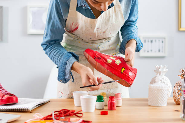 istock Entrepreneur woman working in customizing design studio repainting used sneakers 1309992131