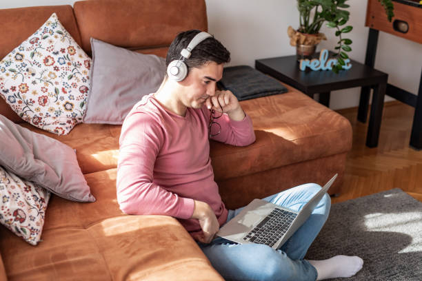 istock Portrait of young man at home, using laptop 1309993367