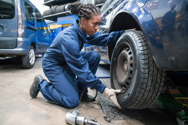 istock Female car mechanic changing wheel 1309994380