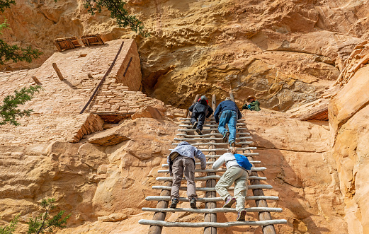 Tourists climbing a ladder to reach the Long House cliff dwelling of the Pueblo civilization, Mesa Verde national park, Colorado, United States of America (USA).