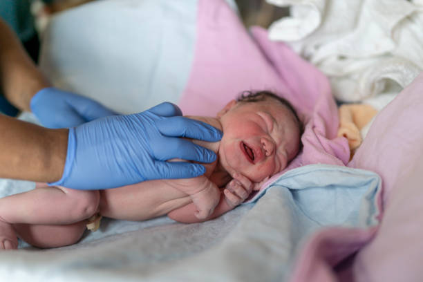 istock Newborn Baby Being Checked By Nurse After Delivery 1309998972