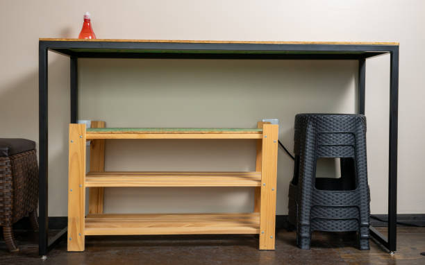 istock Table used for work in home office, for food and multitasking with wooden organizer underneath for sneakers and shoes and benches positioned for later use. Above the table alcohol gel for hand hygiene 1309999156