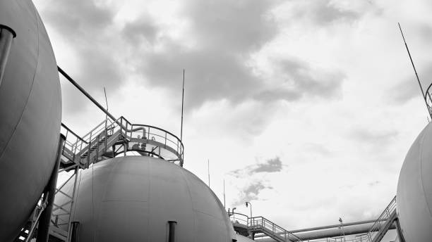 現代の化学生産上の雷保護および安全弁が付いているいくつかの球形のガスホルダーの産業景観のボトムアップの眺め。黒と白の16x9産業石油化学の背景。 - gasholders ストックフォトと画像