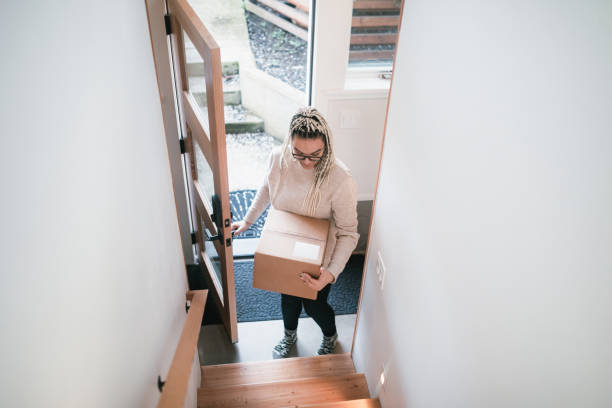 istock Woman Bringing Package Delivery Into Her Home 1310000843