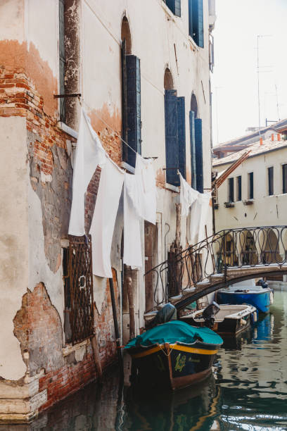 istock White sheets hanging outside shuttered windows above Venetian canal 1310002723