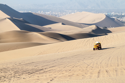 Dune buggy rides the sand dunes in Huacachina desert, Peru