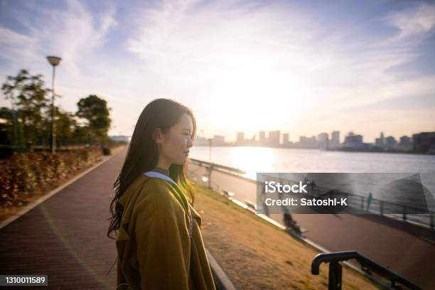 Young Womanj Looking At River At Sunset Time Stock Photo - Download Image Now - Asia, Cityscape, Outdoors