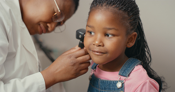 Shot of an adorable little girl having her ears checked during a consultation with a doctor