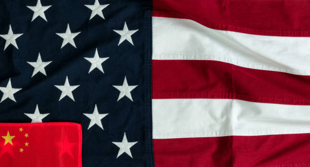 istock Waving US flag with small Chinese flag in lower left corner for Trade War Concept 1310016519