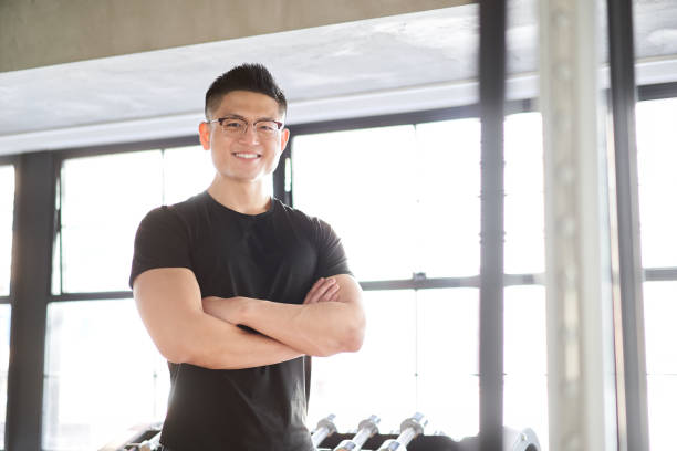 Asian male trainer with a smile and arms folded