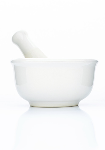 Closeup white ceramic mortar and pestle isolated on white background .