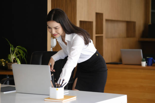 istock Happy businesswoman standing at her workplace and reading email on laptop computer. 1310037623