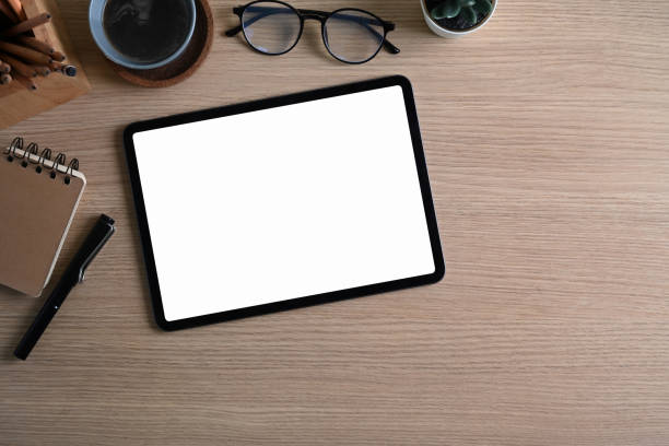 istock Overhead shot of designer workplace with digital tablet, coffee cup, notebook and eye glasses on wooden desk. 1310037626