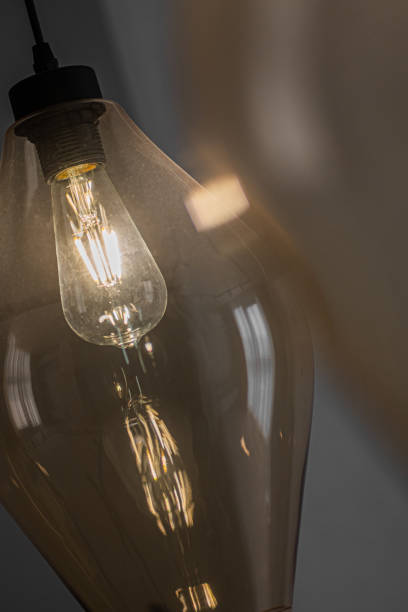 istock Decorative edison style LED light bulb in a transparent glass chandelier. 1310038579