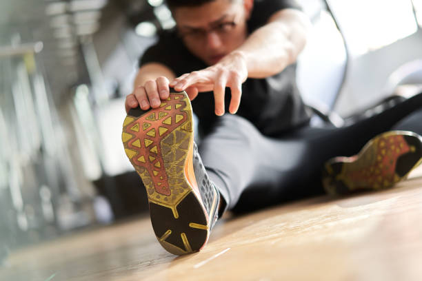 Asian man stretching in a training gym Asian man stretching in a training gym hamstring injury stock pictures, royalty-free photos & images