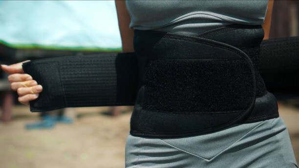 女の子はフィットネスの職業のための汗の撤退と減量のためのベルトのビーチに立っています - belt ストックフォトと画像