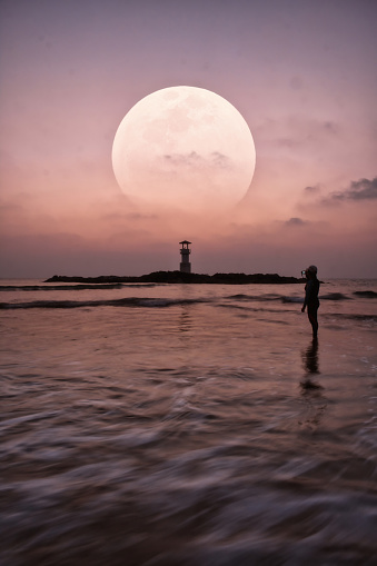 Seascape of Khao Lak with Lighthouse on beach with big moon at Phang Nga, Thailand.