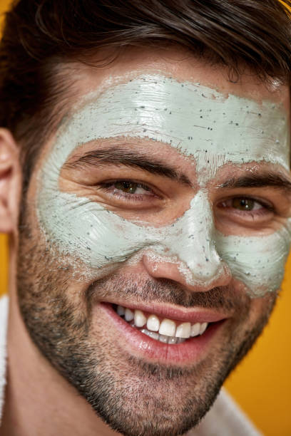 istock Young man with green mask applied on his face 1310041200