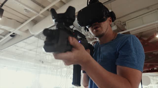Guy playing VR sniper game with gun and glasses